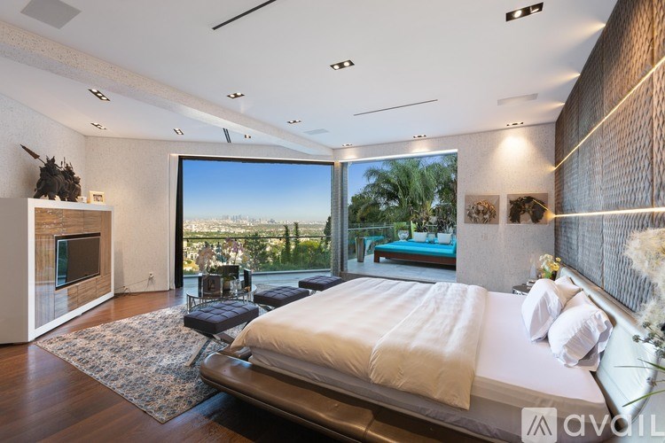 A bedroom with a large bed and a view of the city.