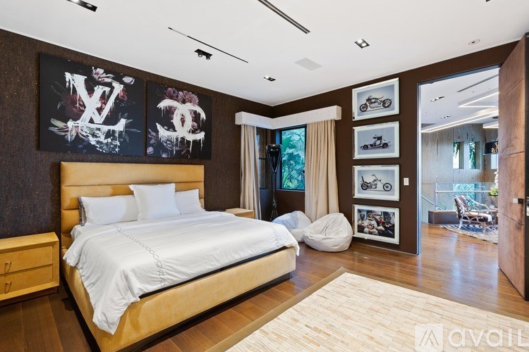 A bedroom with a large bed and a wall with pictures and letters on it.
