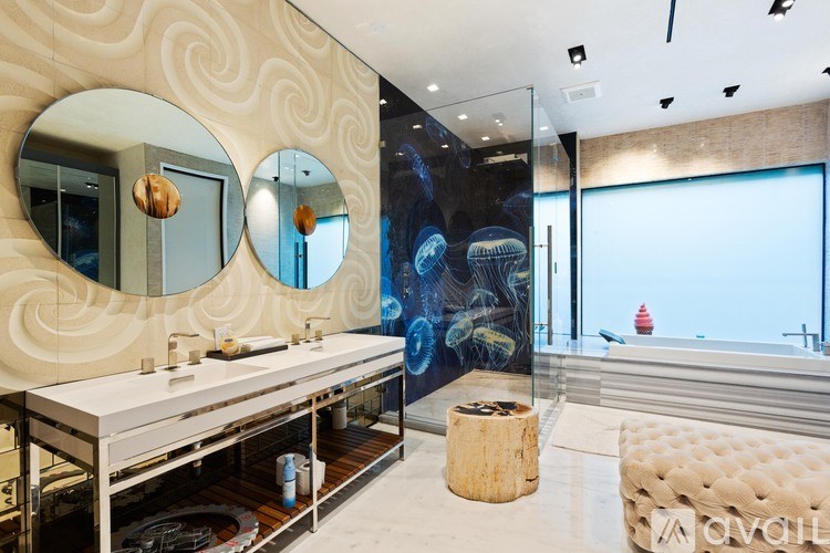 A bathroom with a large mirror and a round wooden stool.