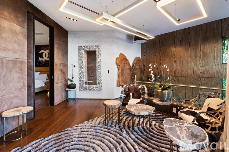 A modern living room with a large rug and a wooden floor.