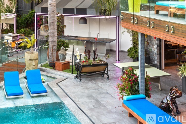 A pool with a blue lounge chair and a wooden bench.
