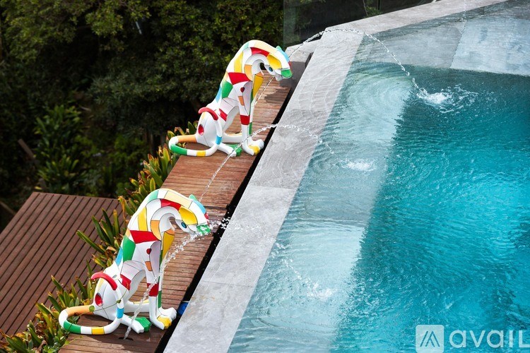 A pool with a wooden deck and a poolside lounge chair.