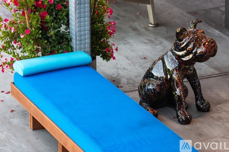 A blue bench with a zebra statue in front of it.