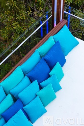 A row of blue pillows on a white couch.