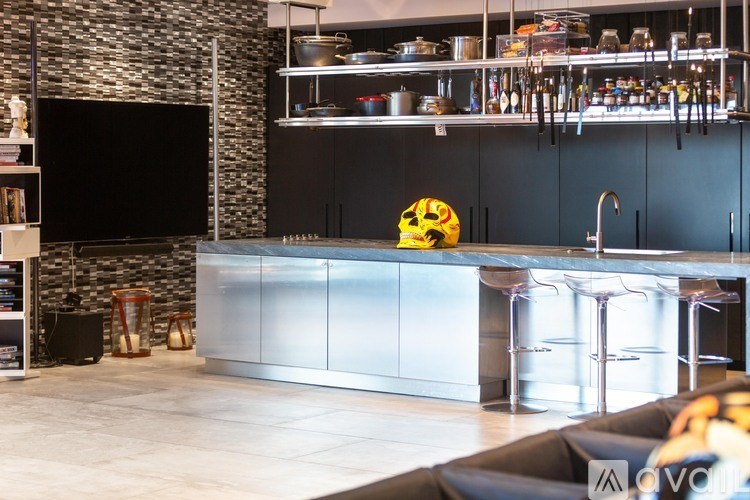 A modern kitchen with a black countertop and stainless steel appliances.