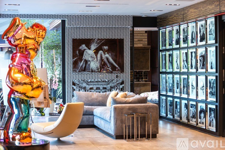 A living room with a large sculpture on the left and a wall of framed pictures on the right.