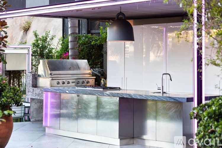 A modern outdoor kitchen with a built-in grill and sink.