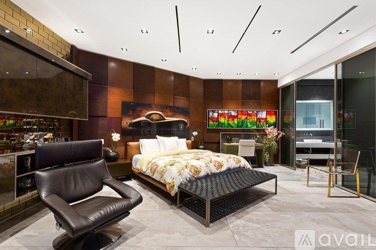 A modern bedroom with a large bed and a black leather chair.