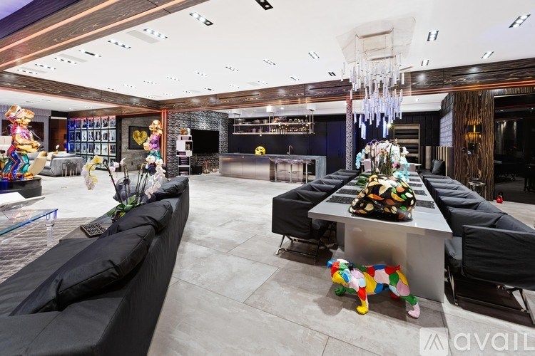 A modern living room with a black sofa and a glass coffee table.