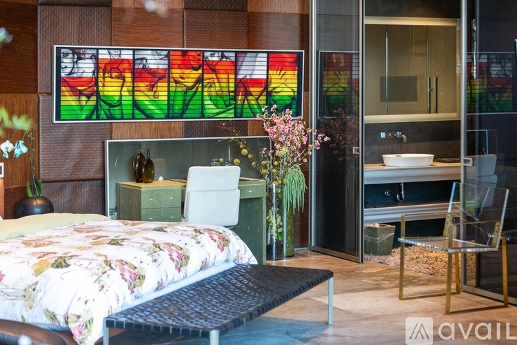 A bedroom with a bed, chair, and a stained glass window.