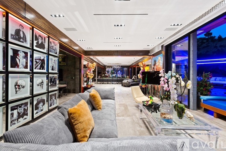 A living room with a grey couch and a glass table.