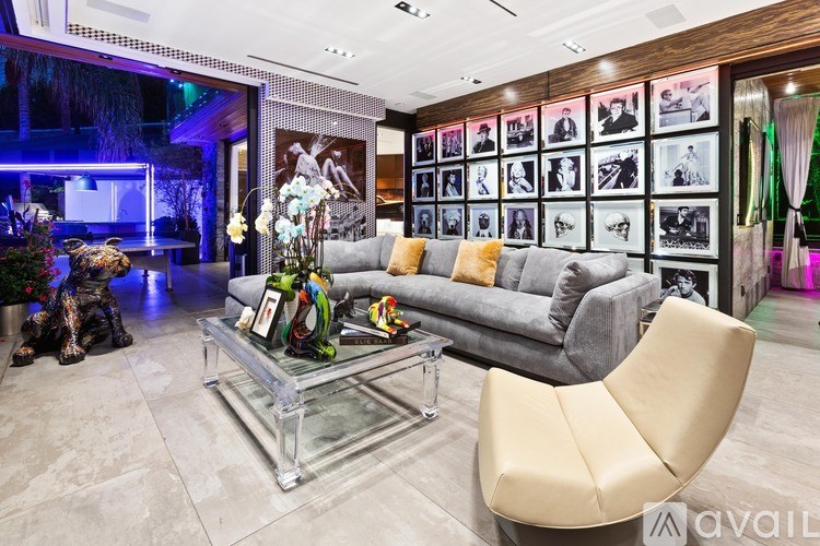 A modern living room with a glass coffee table and a grey sofa.