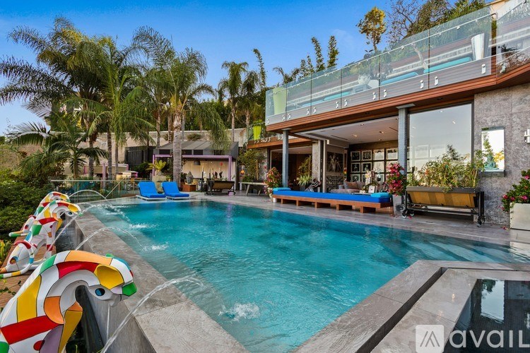 A pool with a slide and a house in the background.
