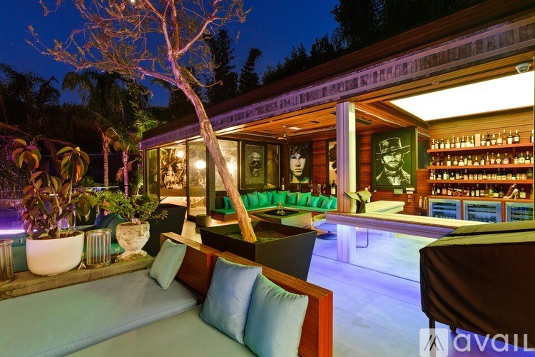 A bar with a pool table and a tree in the background.
