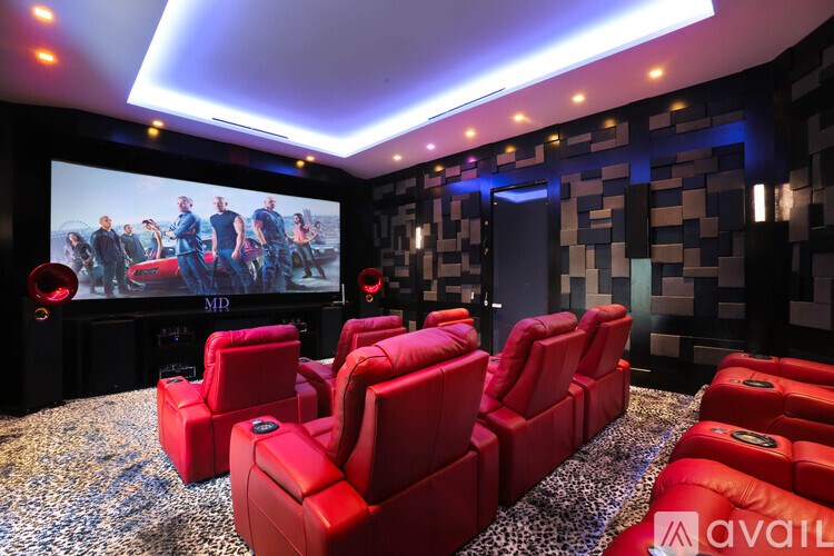 A home theater with red seats and a large screen.
