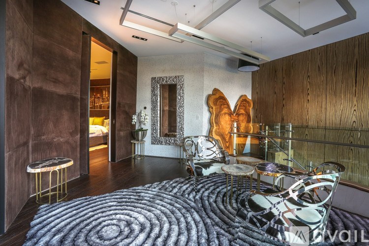 A room with a large rug and a chair with a unique design.