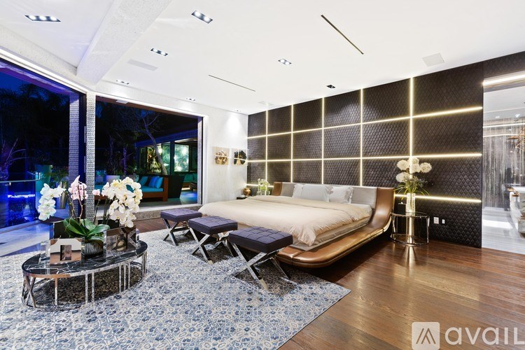 A modern bedroom with a large bed and a glass wall.