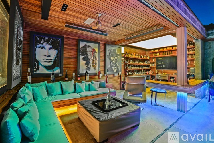 A modern living room with a green couch and a wooden ceiling.