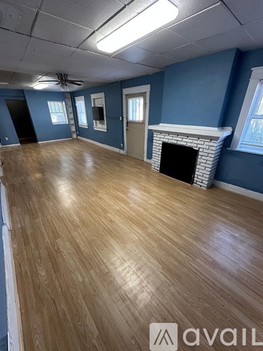 A room with wooden flooring and a stone wall.