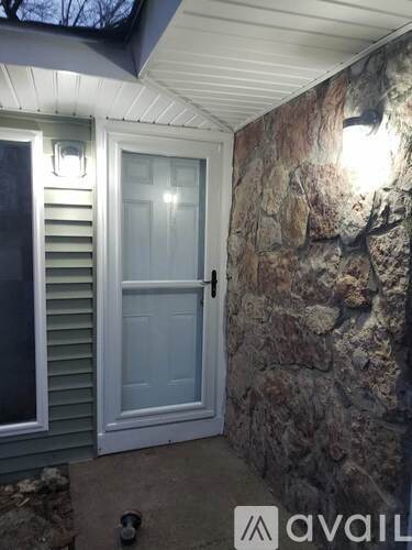A white door is on the left and a stone wall is on the right.
