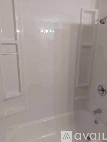 A white bathroom with a glass shower door and a white door.