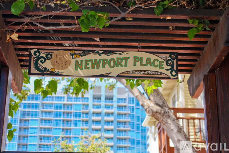 A sign that says Newport Place is hanging from a wooden structure.