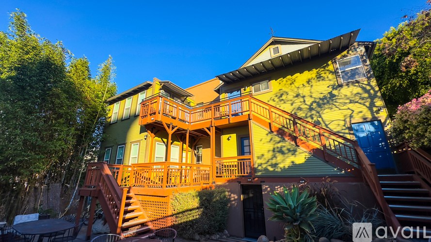 A house with a yellow and green exterior is available for rent.