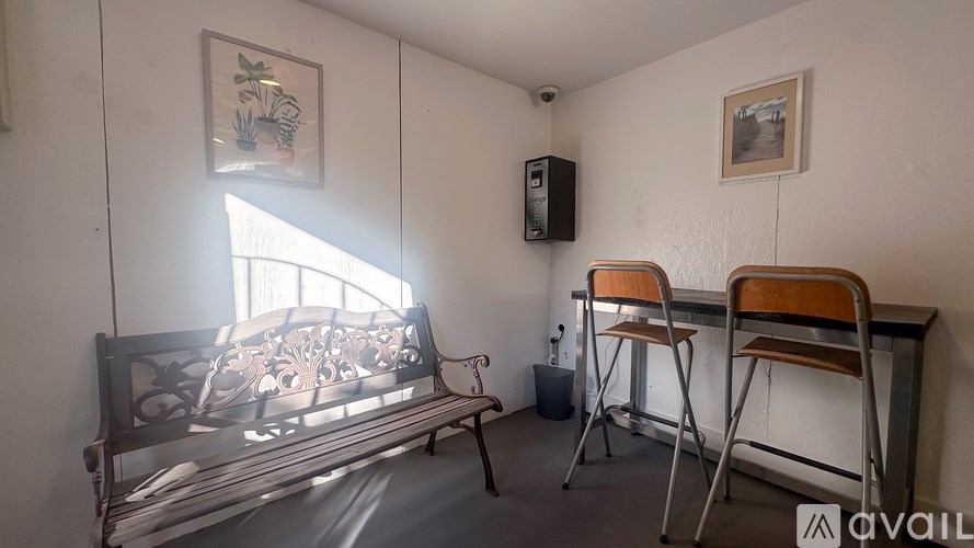 A room with a bench, chairs, and a speaker.