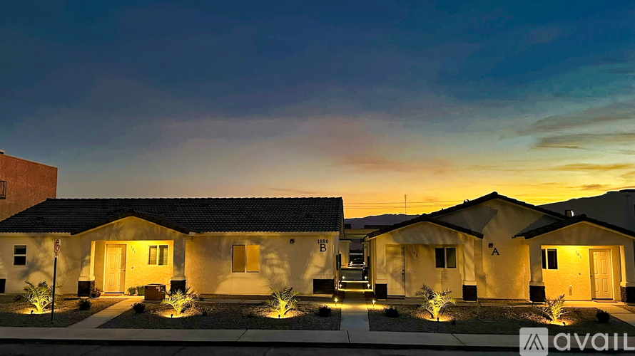 A row of houses are lit up at dusk.