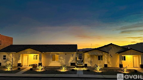 A row of houses are lit up at dusk.