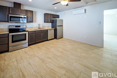 A kitchen with wooden cabinets and a tile floor.