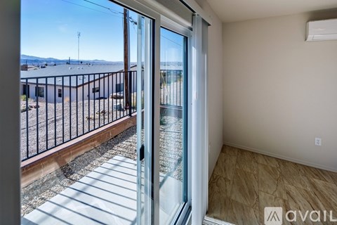 A balcony with a view of a parking lot and a building.