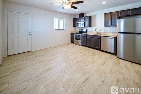 A kitchen with wooden flooring and stainless steel appliances.
