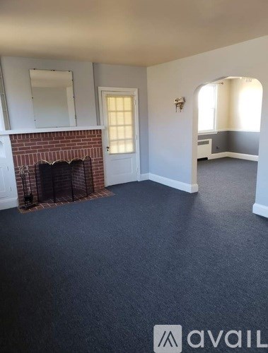 A room with a fireplace and a mirror on the wall.