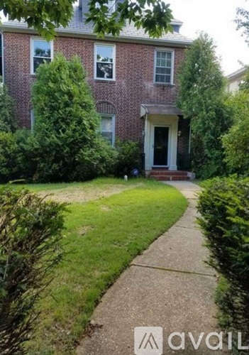 A brick house with a front yard and a sidewalk.
