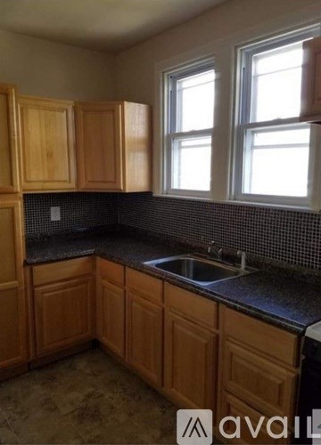 A kitchen with wooden cabinets and a black countertop.
