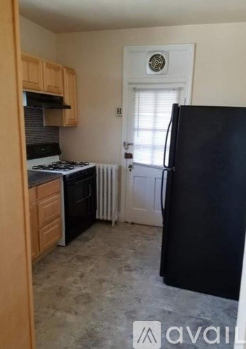 A kitchen with black appliances and wooden cabinets.