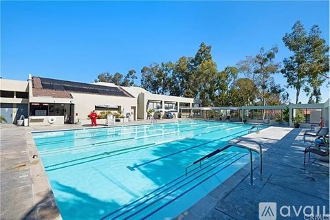 A large outdoor swimming pool with a diving board and lane markers.