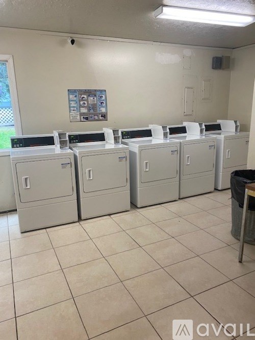 A row of white copiers are lined up in a room.