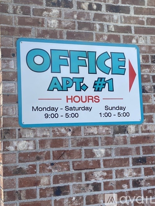 A sign on a brick wall that says Office Apt. #1 Hours.