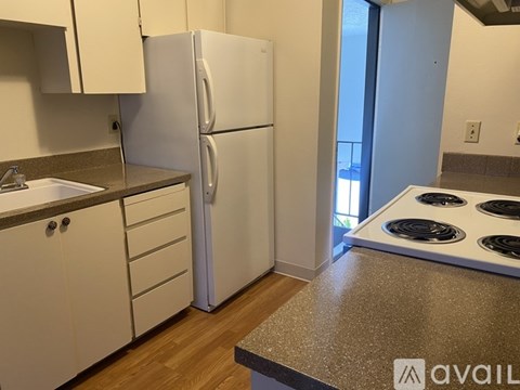 A kitchen with a white refrigerator, white cabinets, and a stove top oven.