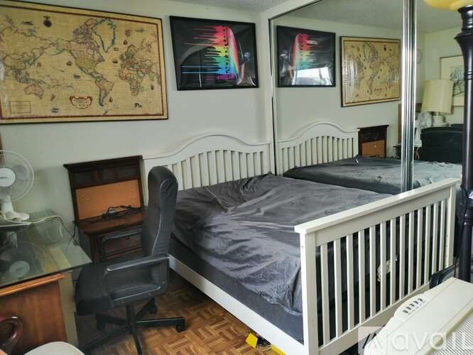 A bedroom with a white bed and a chair.