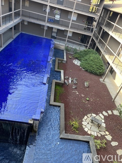 A blue tarp covers a pool in a courtyard surrounded by apartment buildings.