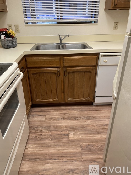 A spacious room with wooden flooring and a ceiling fan.