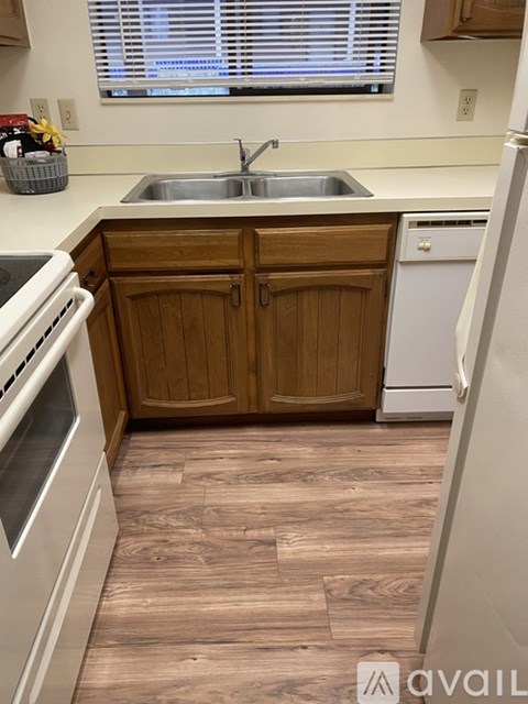 A spacious room with wooden flooring and a ceiling fan.