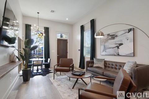 A living room with brown leather furniture and a large painting on the wall.