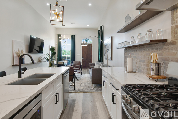 A modern kitchen with a black stove top oven and white countertops.