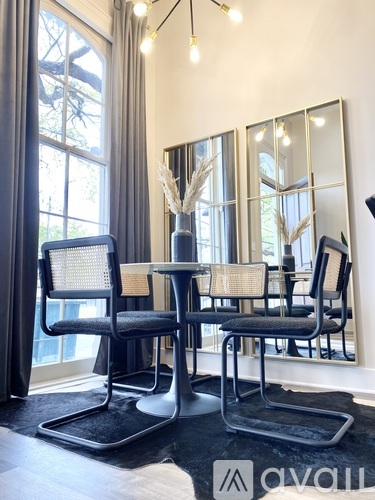 A modern dining room with a glass table and chairs.