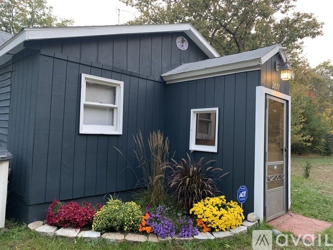 A blue house with a white window and a grey door.