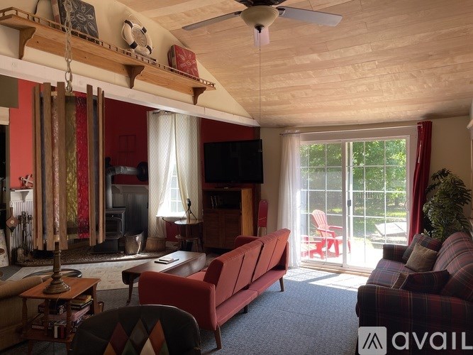 A living room with a red couch and a television.